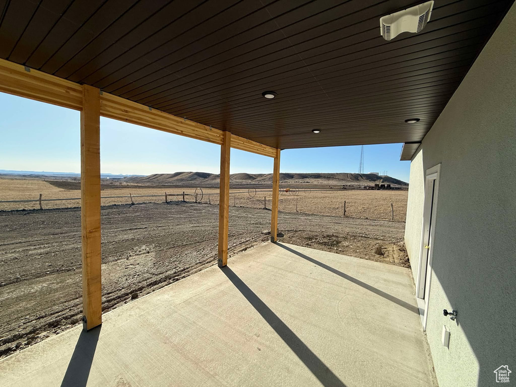 View of patio featuring a mountain view, a rural view, and fence