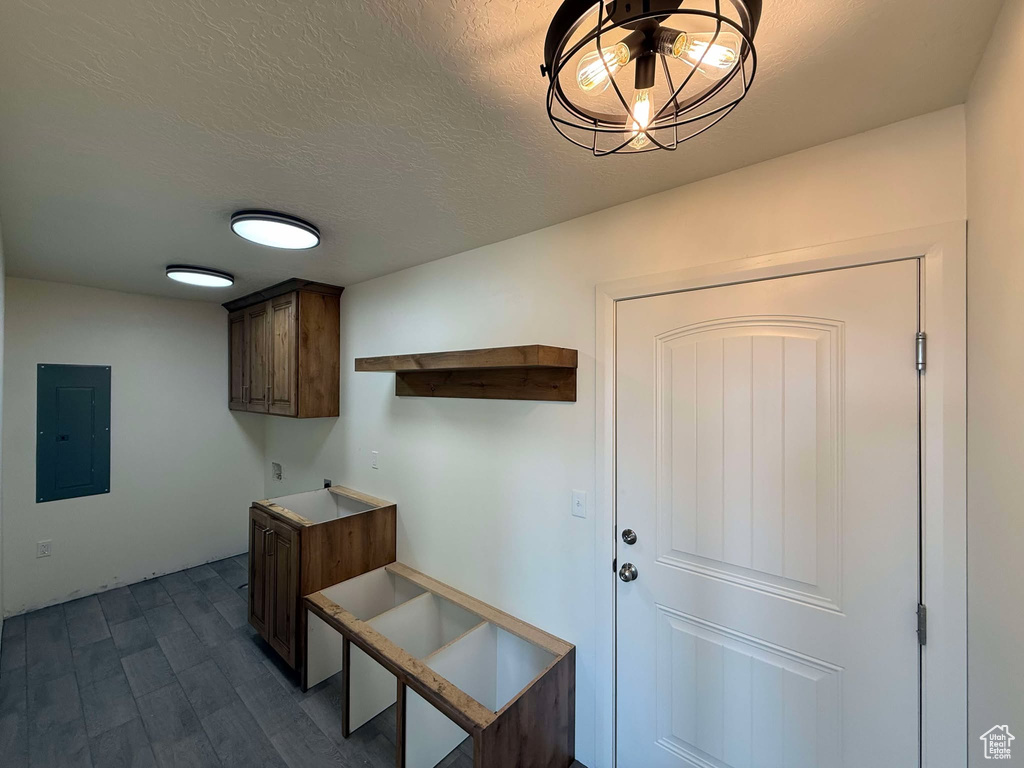 Interior space featuring electric panel, dark wood finished floors, and a textured ceiling