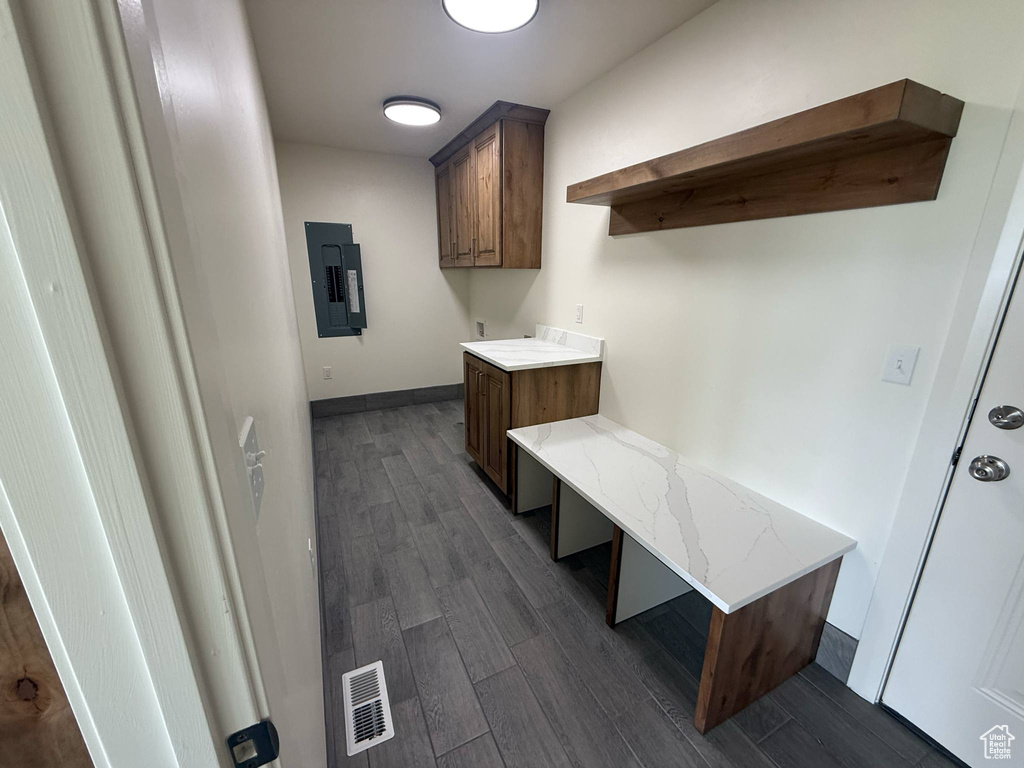 Mudroom with electric panel, dark wood-style floors, and baseboards