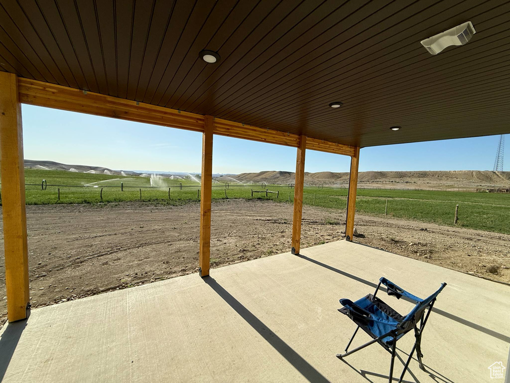 View of patio / terrace featuring a view of rural / pastoral area and a mountain view