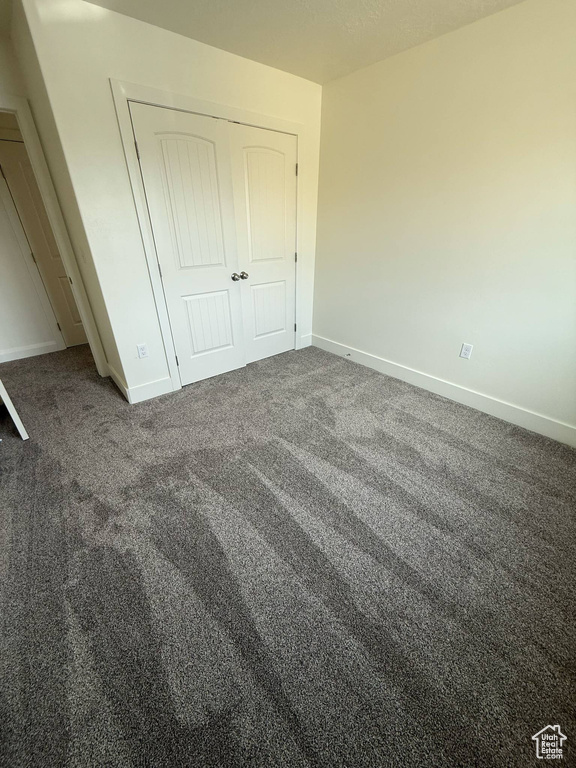 Unfurnished bedroom with carpet, baseboards, and a closet