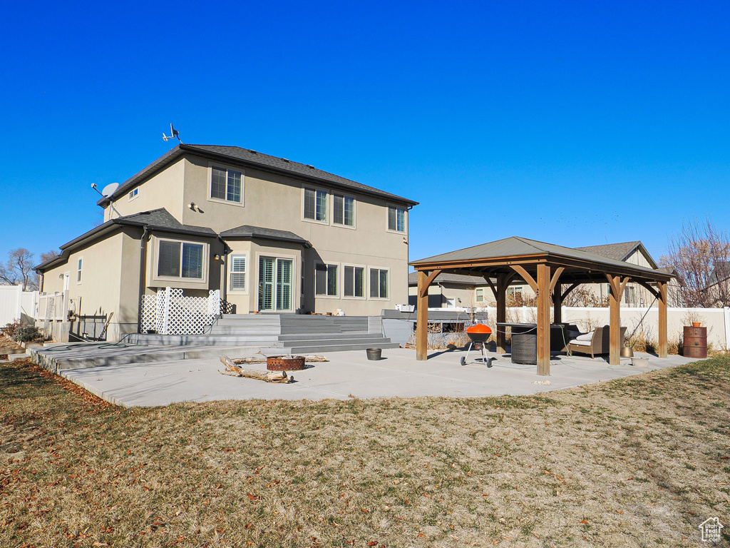 Back of house with a gazebo, a lawn, and a patio