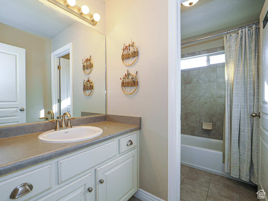 Bathroom with tile patterned flooring, vanity, and shower / bath combo with shower curtain