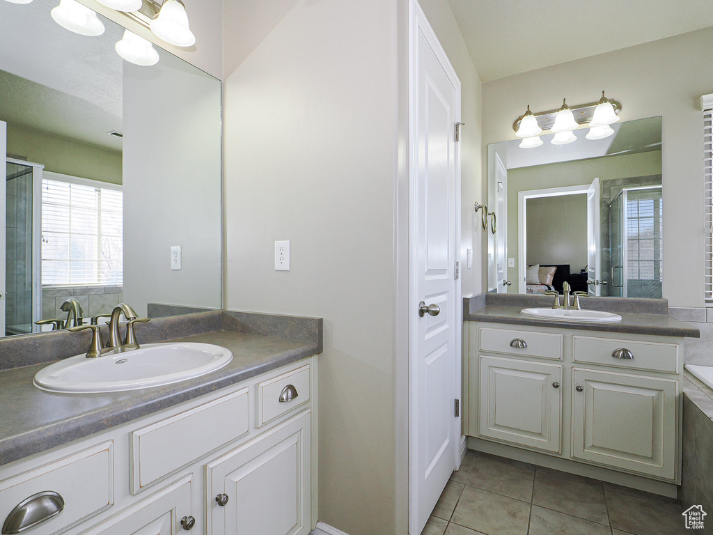 Bathroom with walk in shower, vanity, and tile patterned floors