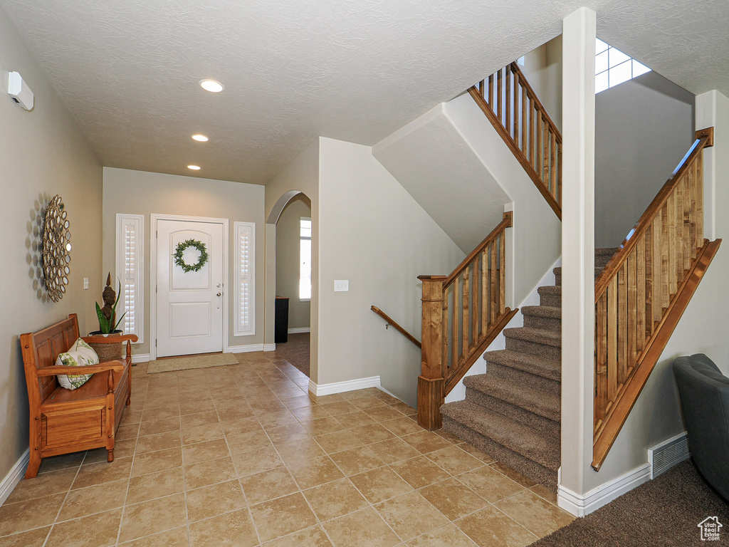 Entrance foyer with a textured ceiling and a wealth of natural light