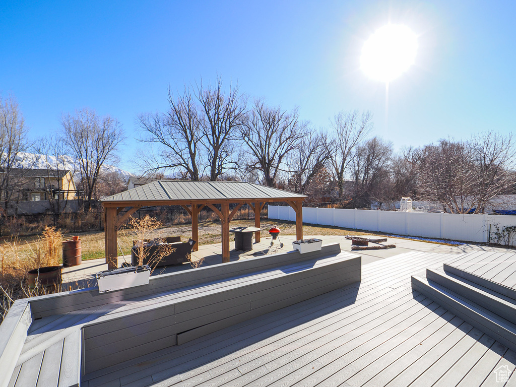 Wooden deck featuring an outdoor fire pit and a gazebo