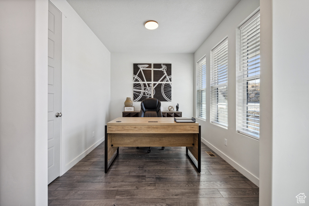 Office space featuring visible vents, baseboards, and dark wood-type flooring