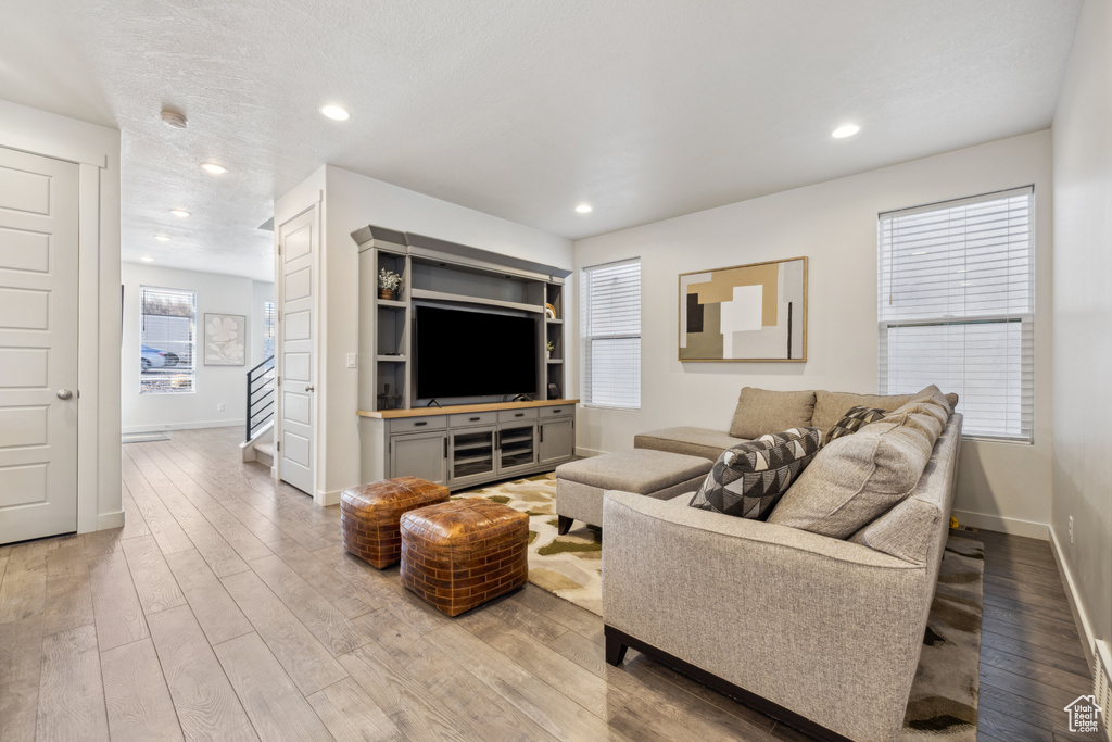 Living room featuring light wood finished floors, stairway, recessed lighting, and baseboards