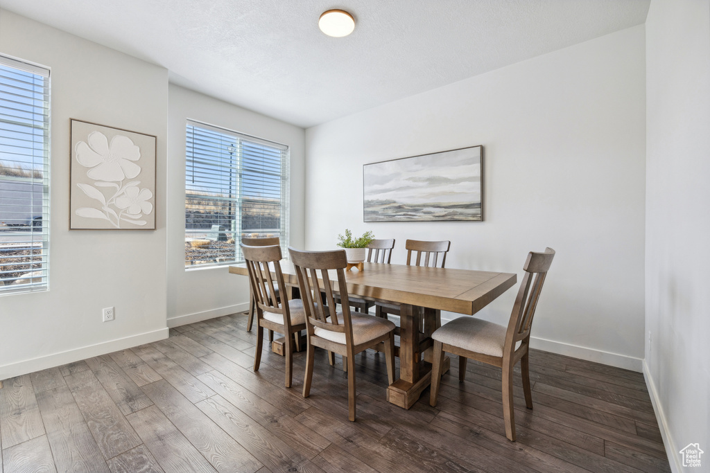 Dining room featuring dark wood finished floors and baseboards
