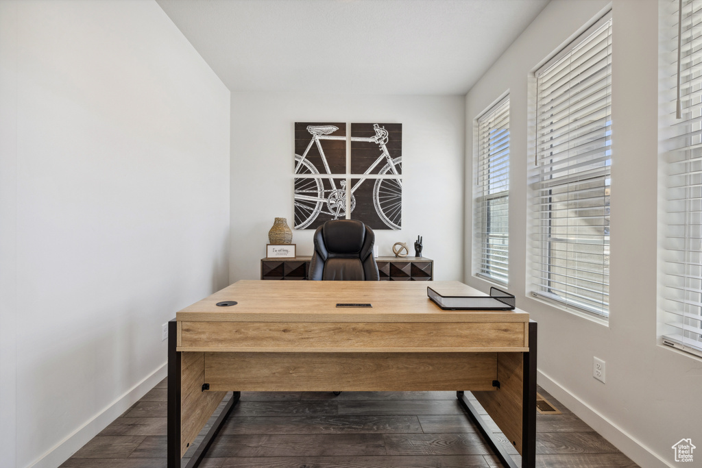 Office space featuring baseboards and dark wood-style flooring
