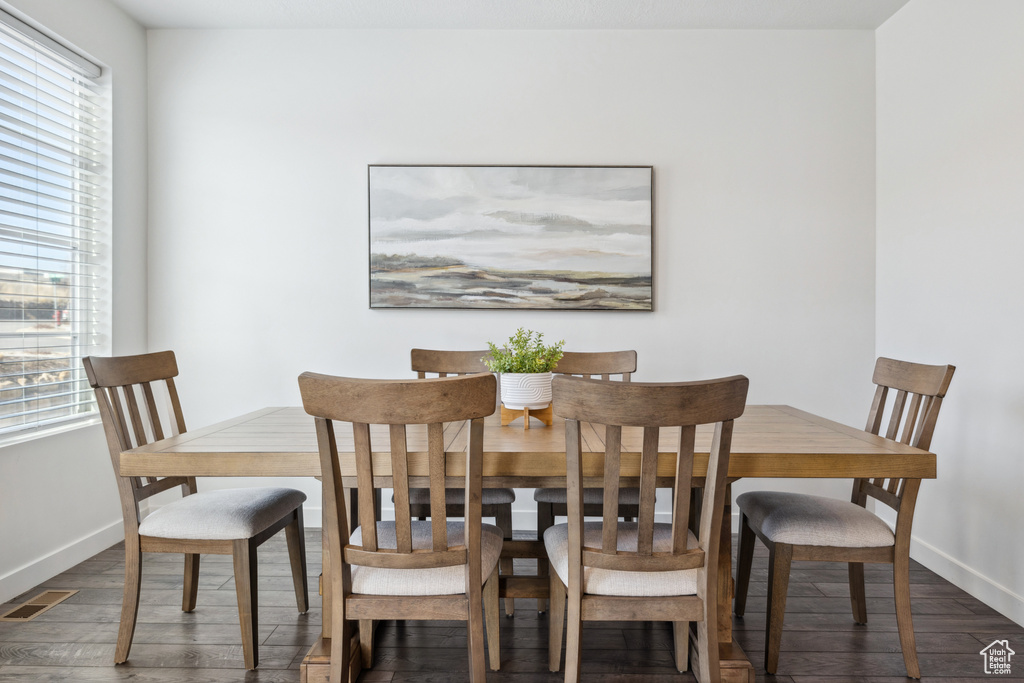 Dining room featuring baseboards, visible vents, and wood finished floors