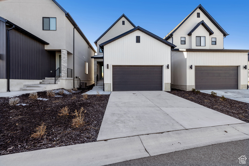 Modern inspired farmhouse featuring a garage and driveway