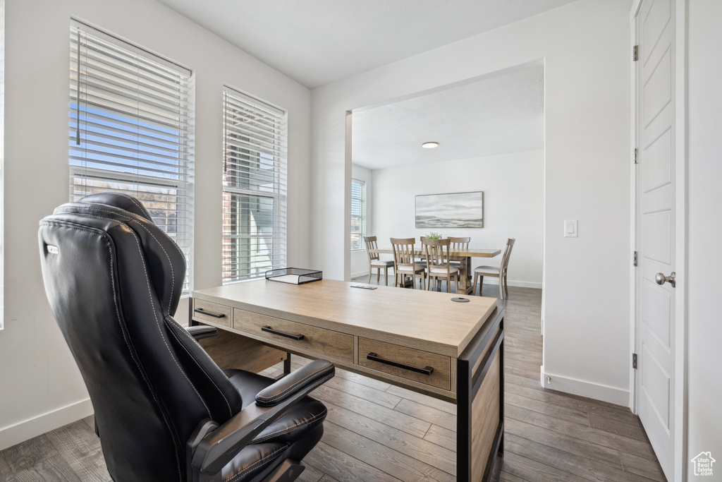 Office space with baseboards and dark wood-style flooring