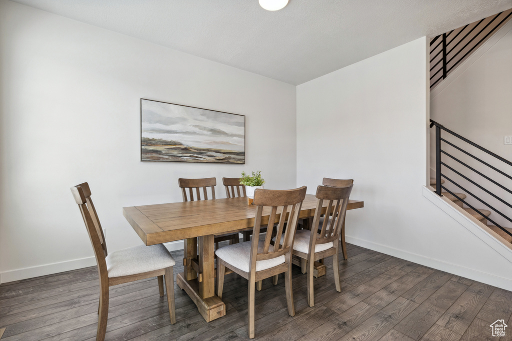 Dining room featuring baseboards, stairway, and wood finished floors