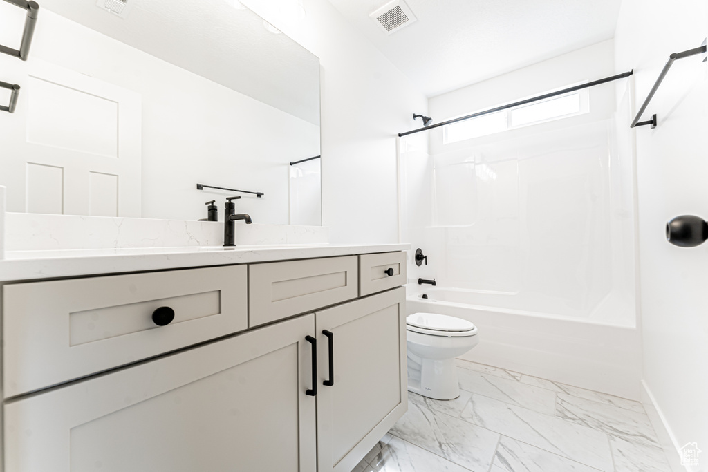 Bathroom with vanity, bathing tub / shower combination, toilet, marble finish floor, and visible vents