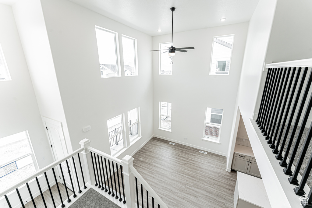 Interior space featuring recessed lighting, wood finished floors, ceiling fan, baseboards, and a towering ceiling