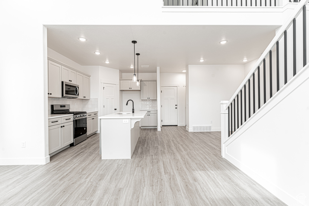 Kitchen featuring a sink, light wood-style flooring, stainless steel appliances, and visible vents