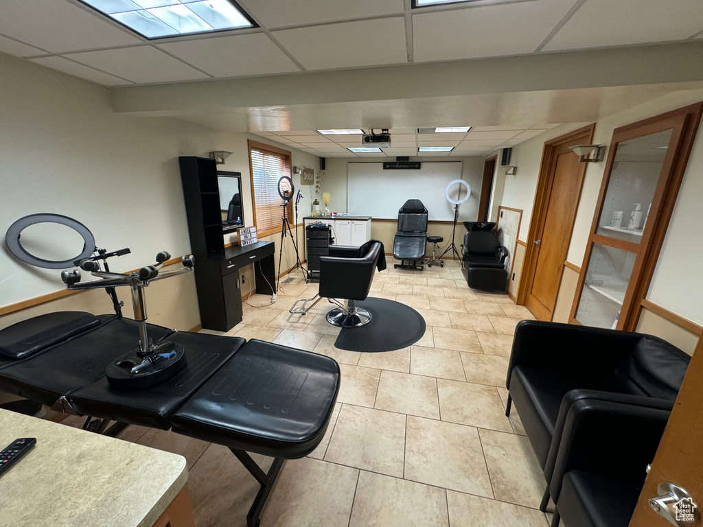 Exercise room with a drop ceiling and light tile patterned floors