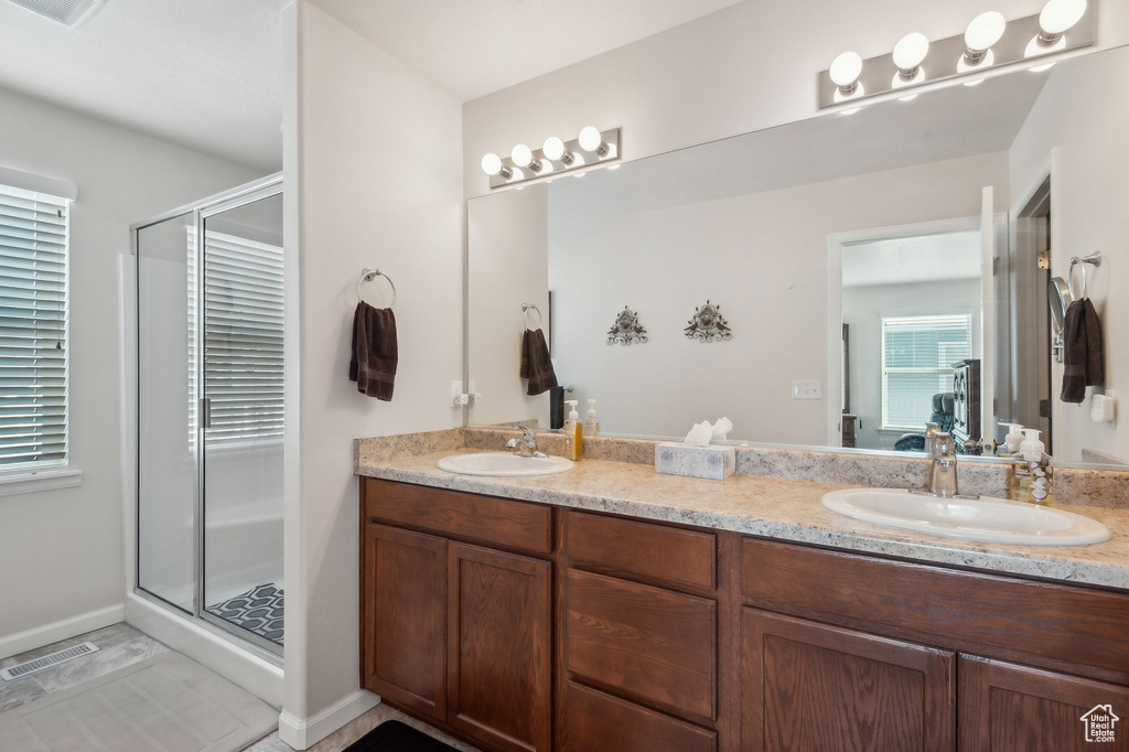 Bathroom with vanity, tile patterned flooring, and a shower with door