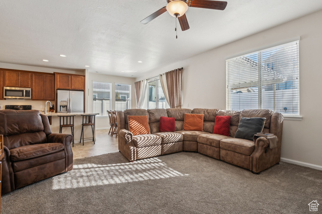 Carpeted living room with ceiling fan