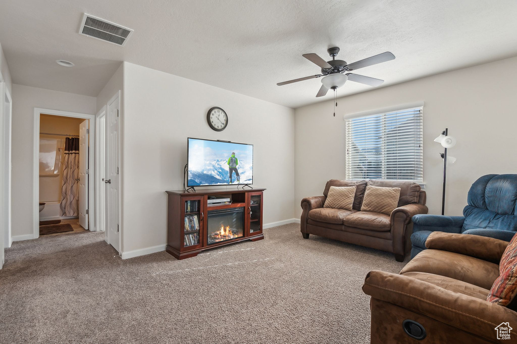 Living room featuring carpet floors and ceiling fan