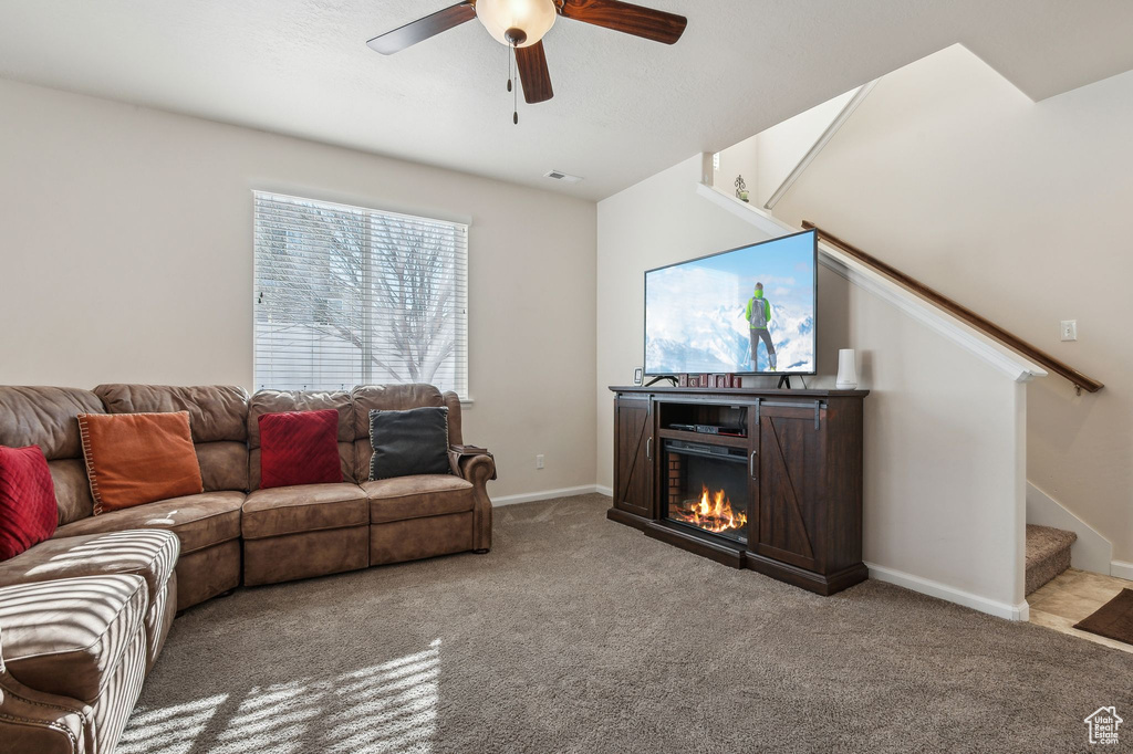 Carpeted living room featuring ceiling fan