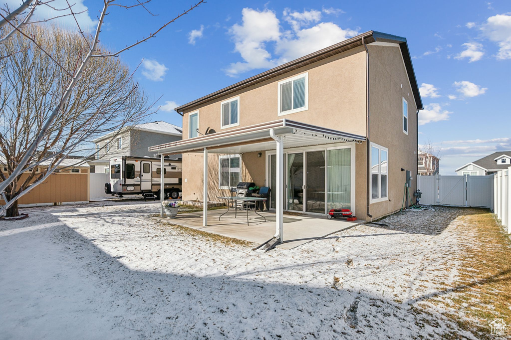 Snow covered house featuring a patio area