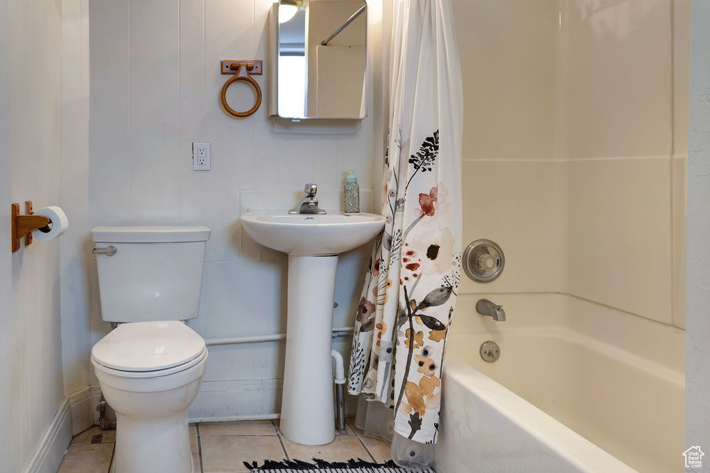 Full bathroom with toilet, sink, tile patterned flooring, and shower / bath combo