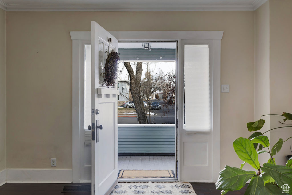 Doorway featuring dark hardwood / wood-style floors and ornamental molding