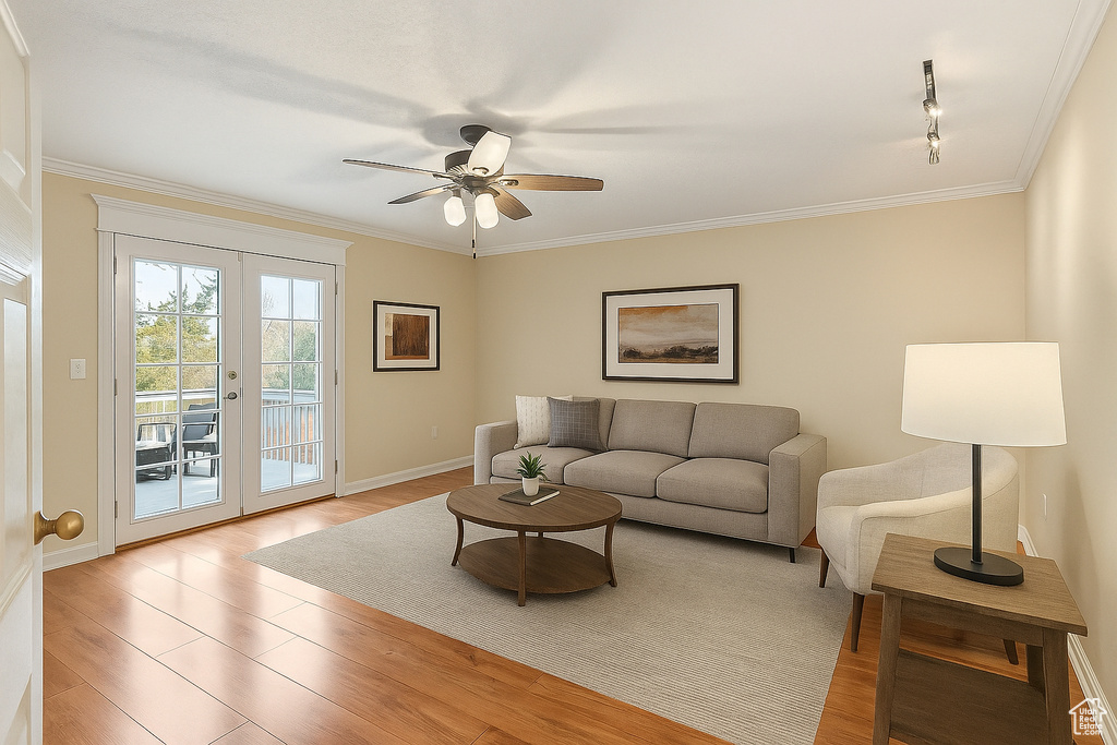 Living area with light wood finished floors, a ceiling fan, crown molding, french doors, and track lighting