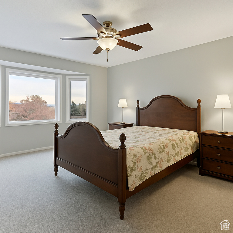 Bedroom featuring light carpet, baseboards, and ceiling fan