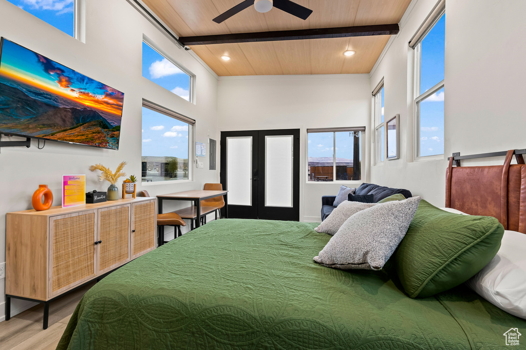 Bedroom with ceiling fan, french doors, beamed ceiling, and hardwood / wood-style floors