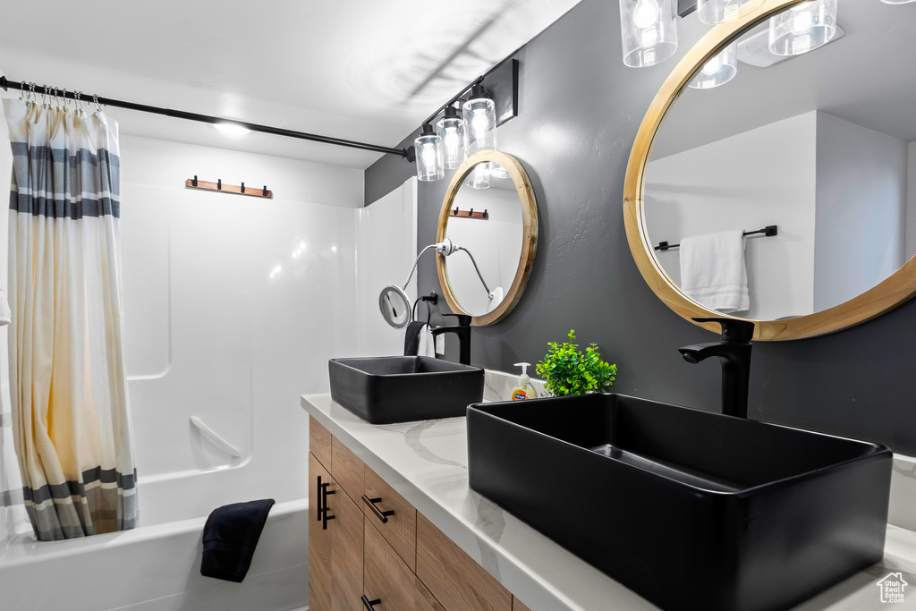 Bathroom featuring vanity and shower / tub combo with curtain