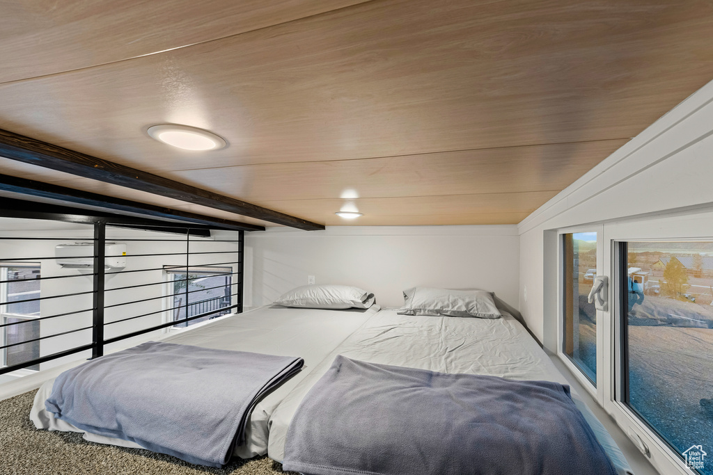 Carpeted bedroom featuring wood ceiling and beamed ceiling