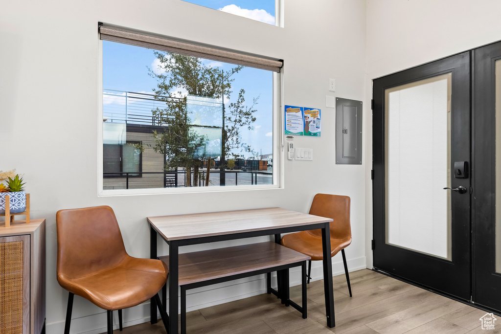 Dining room featuring a healthy amount of sunlight, light hardwood / wood-style floors, and electric panel