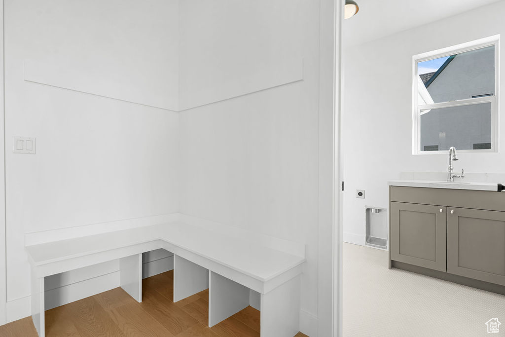 Mudroom with light wood-type flooring and sink
