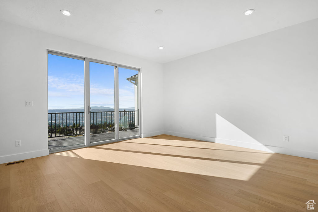 Unfurnished room featuring hardwood / wood-style floors and a water view