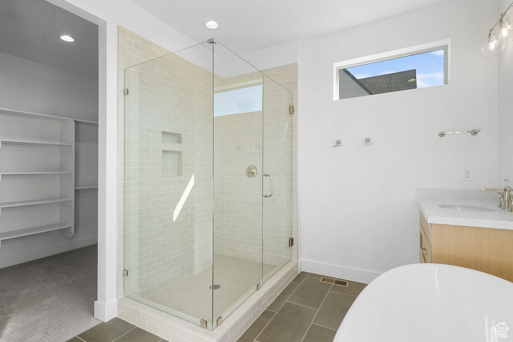 Bathroom featuring vanity, tile patterned flooring, and a shower with door