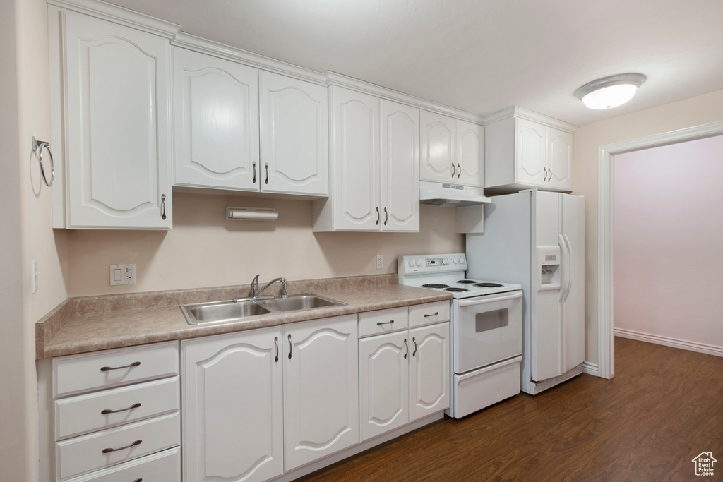 Kitchen with dark wood-type flooring, sink, white appliances, and white cabinets