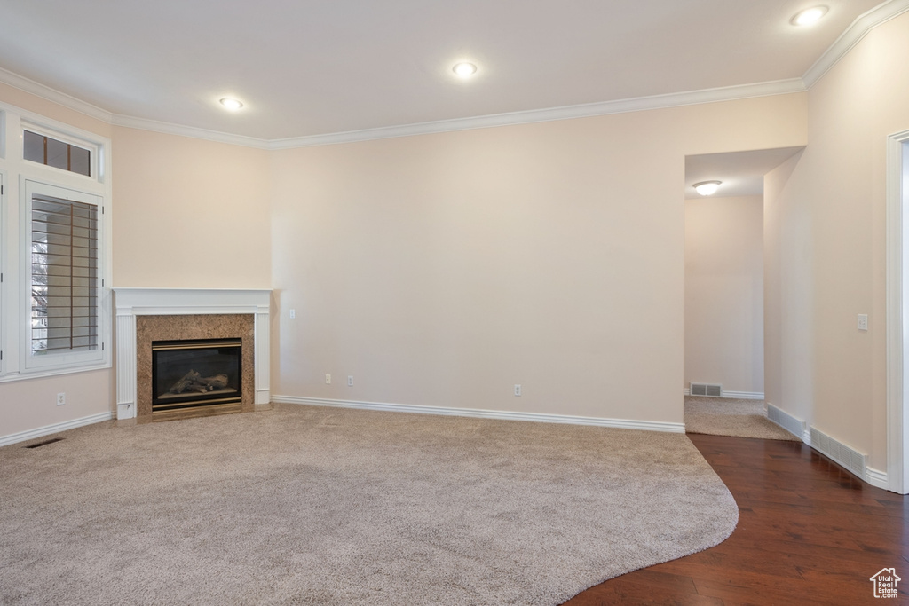 Unfurnished living room featuring dark hardwood / wood-style flooring and crown molding