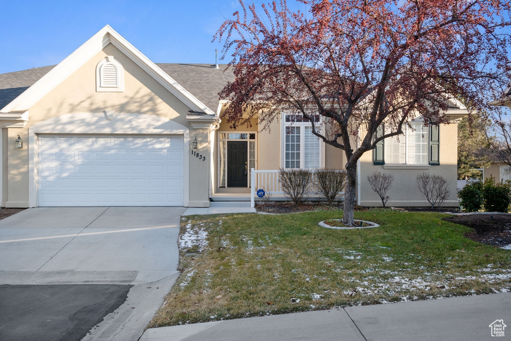 View of front of home with a front yard and a garage