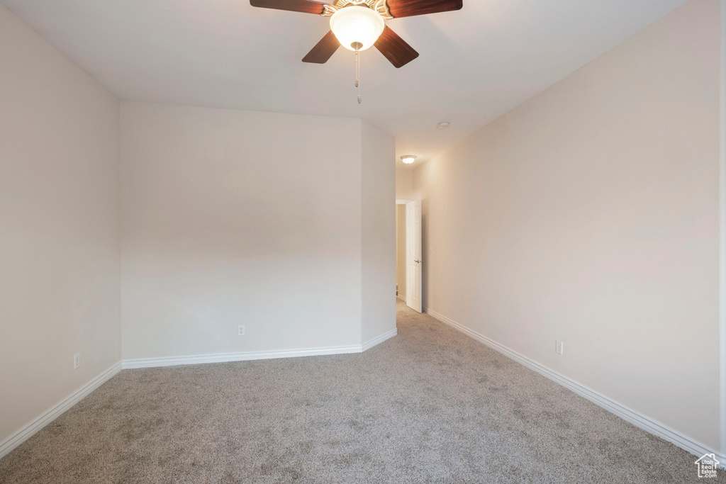 Carpeted empty room with ceiling fan