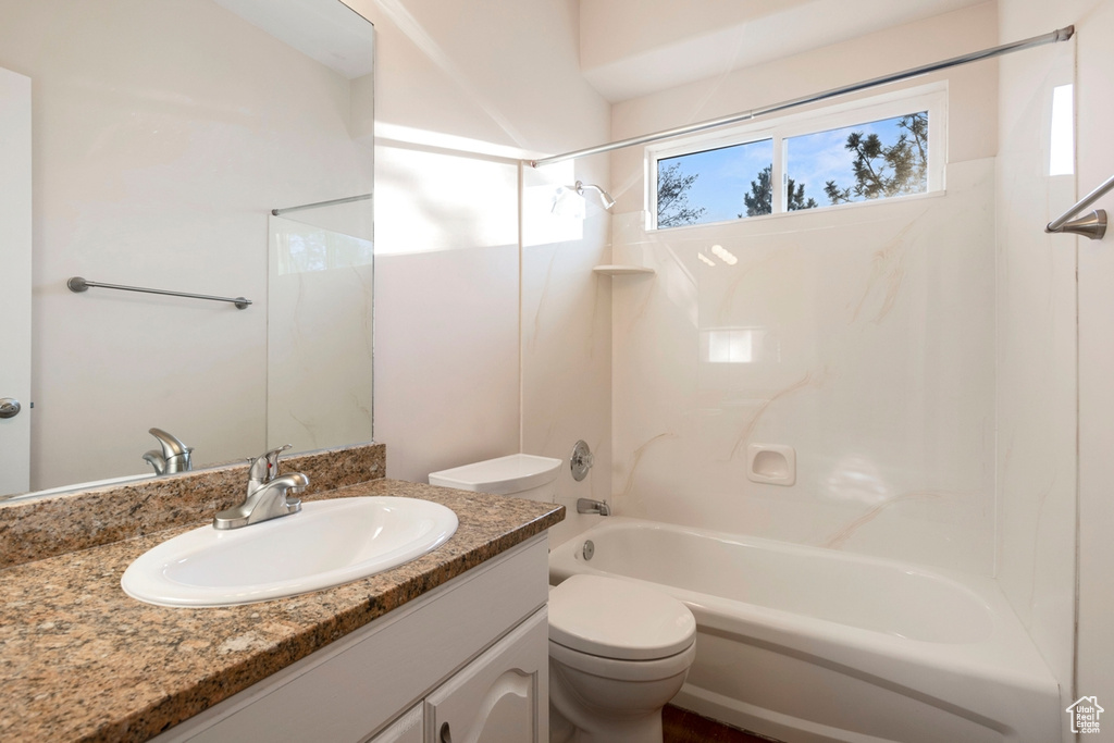 Full bathroom featuring toilet, vanity, and bathing tub / shower combination