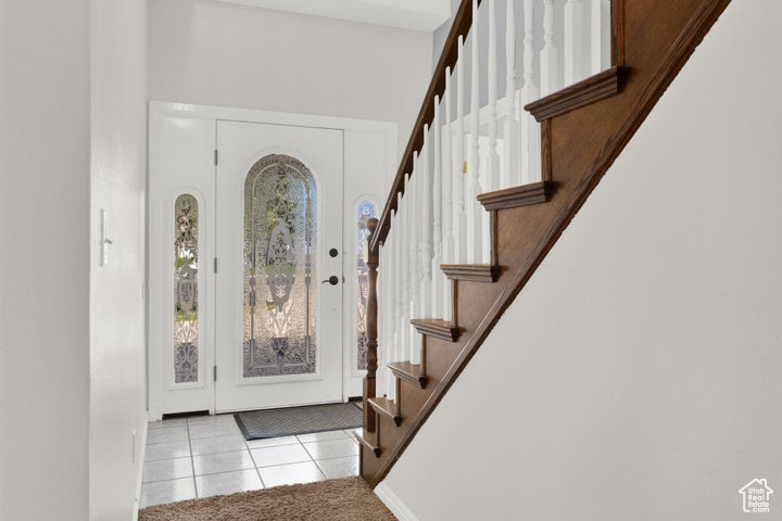 Tiled foyer entrance featuring a towering ceiling