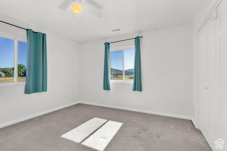 Spare room featuring light colored carpet and ceiling fan