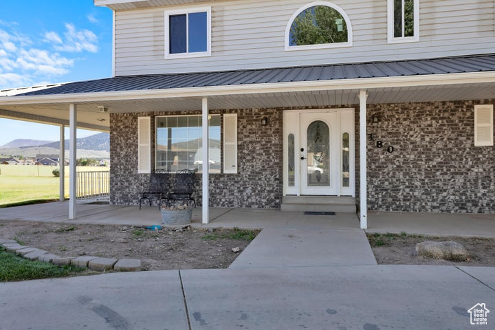 Doorway to property with covered porch and a mountain view