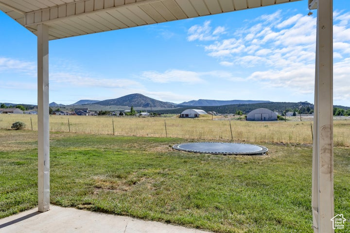 View of yard featuring a mountain view, a trampoline, and a rural view