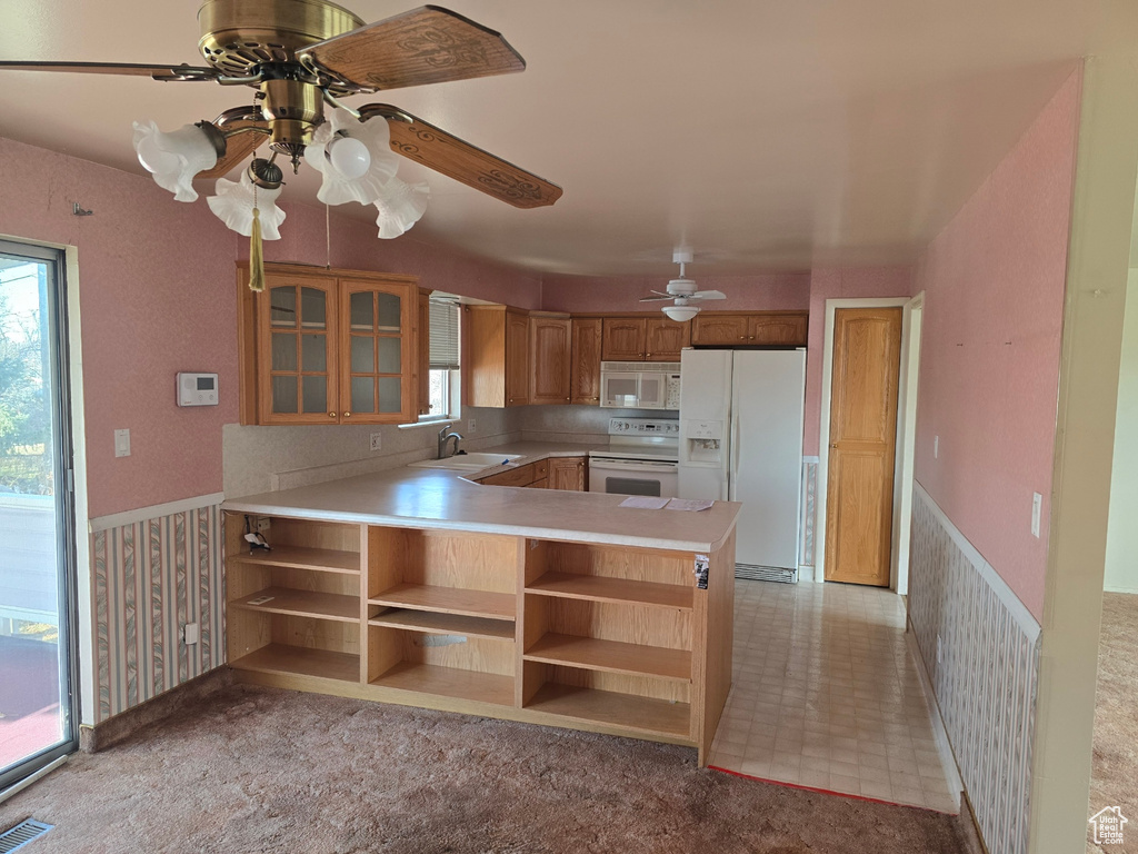 Kitchen featuring white appliances, light carpet, sink, kitchen peninsula, and ceiling fan
