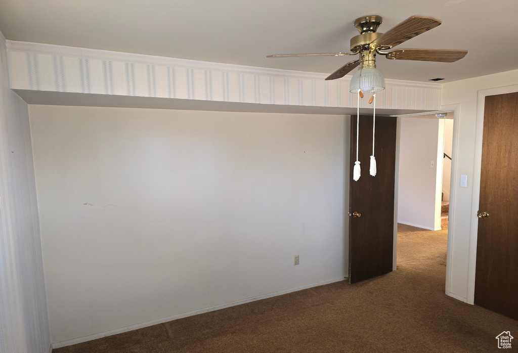 Spare room featuring ceiling fan and carpet