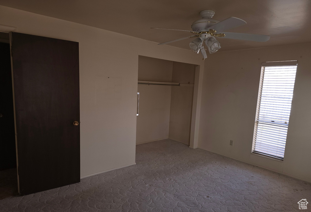 Unfurnished bedroom with a closet, ceiling fan, and carpet flooring